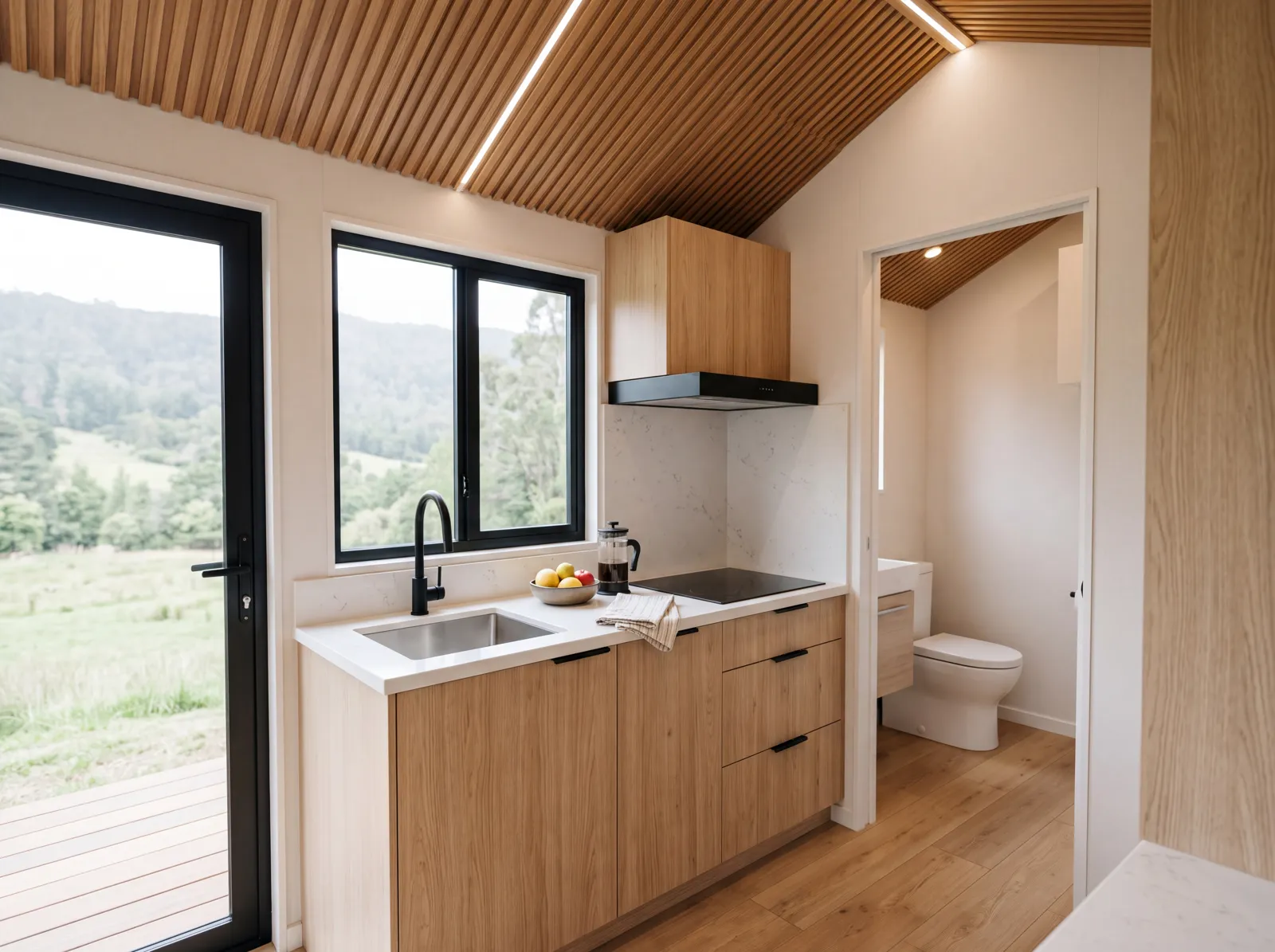 Cocina de la SIP-S 20 con muebles de madera, tablero de cuarzo, lavadero de acero e inducción